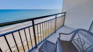 Ein Balkon mit Blick auf Strand und Meer.