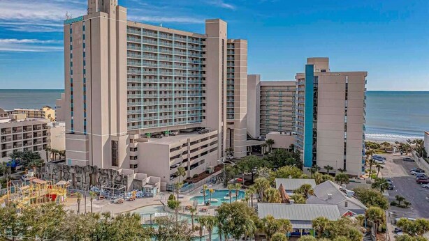A large hotel with multiple floors and a pool area. - 3BR in Sand Dunes Resort Ocean View - Great Views (Myrtle Beach)