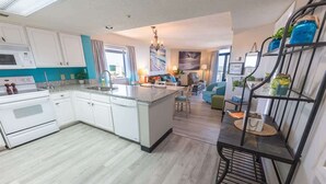 A modern kitchen with white cabinets, a granite countertop, and a central island. - 3BR in Sand Dunes Resort Ocean View - Great Views (Myrtle Beach)
