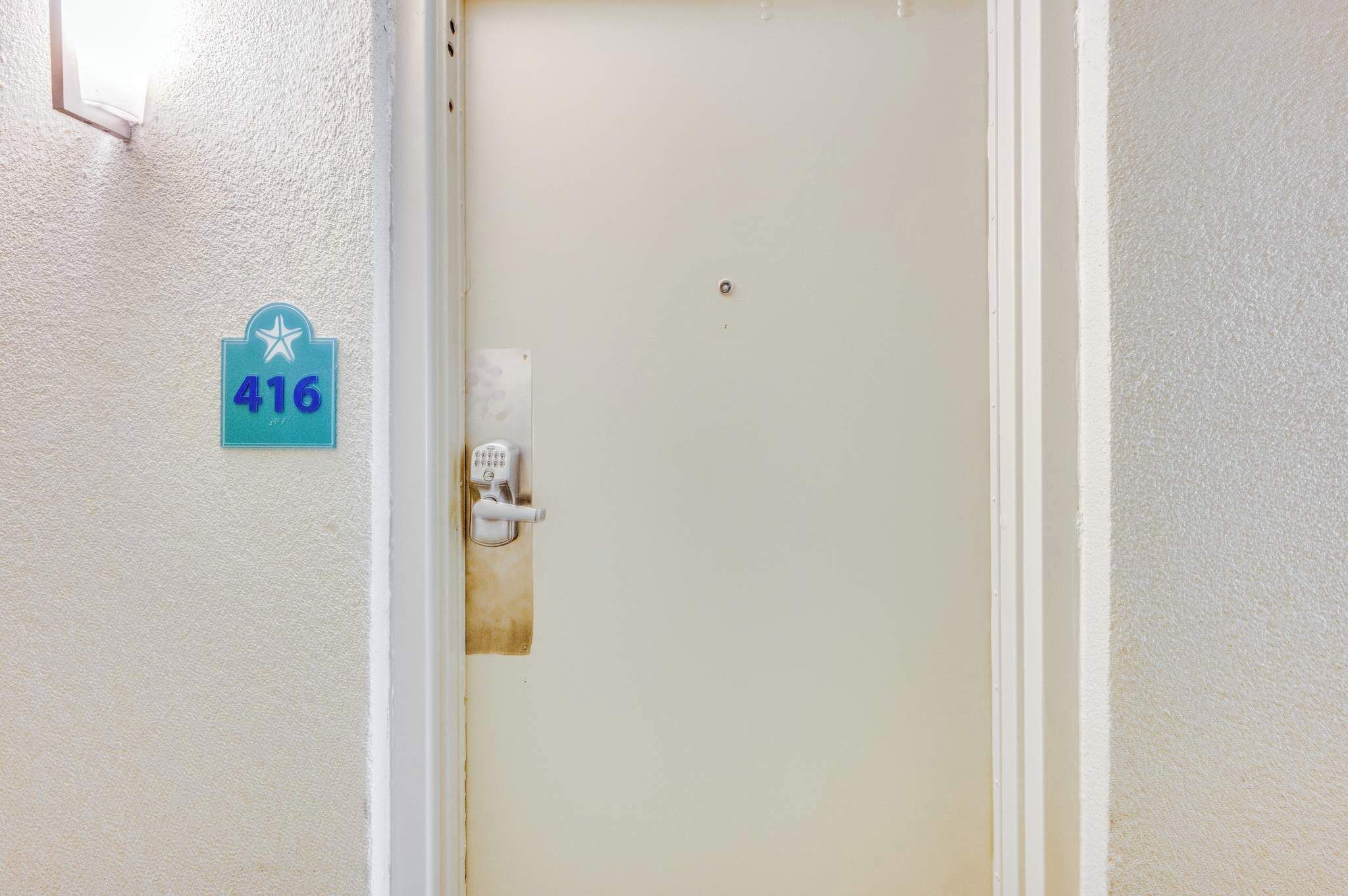 Una puerta con un letrero con el número 416 y una cerradura electrónica.
