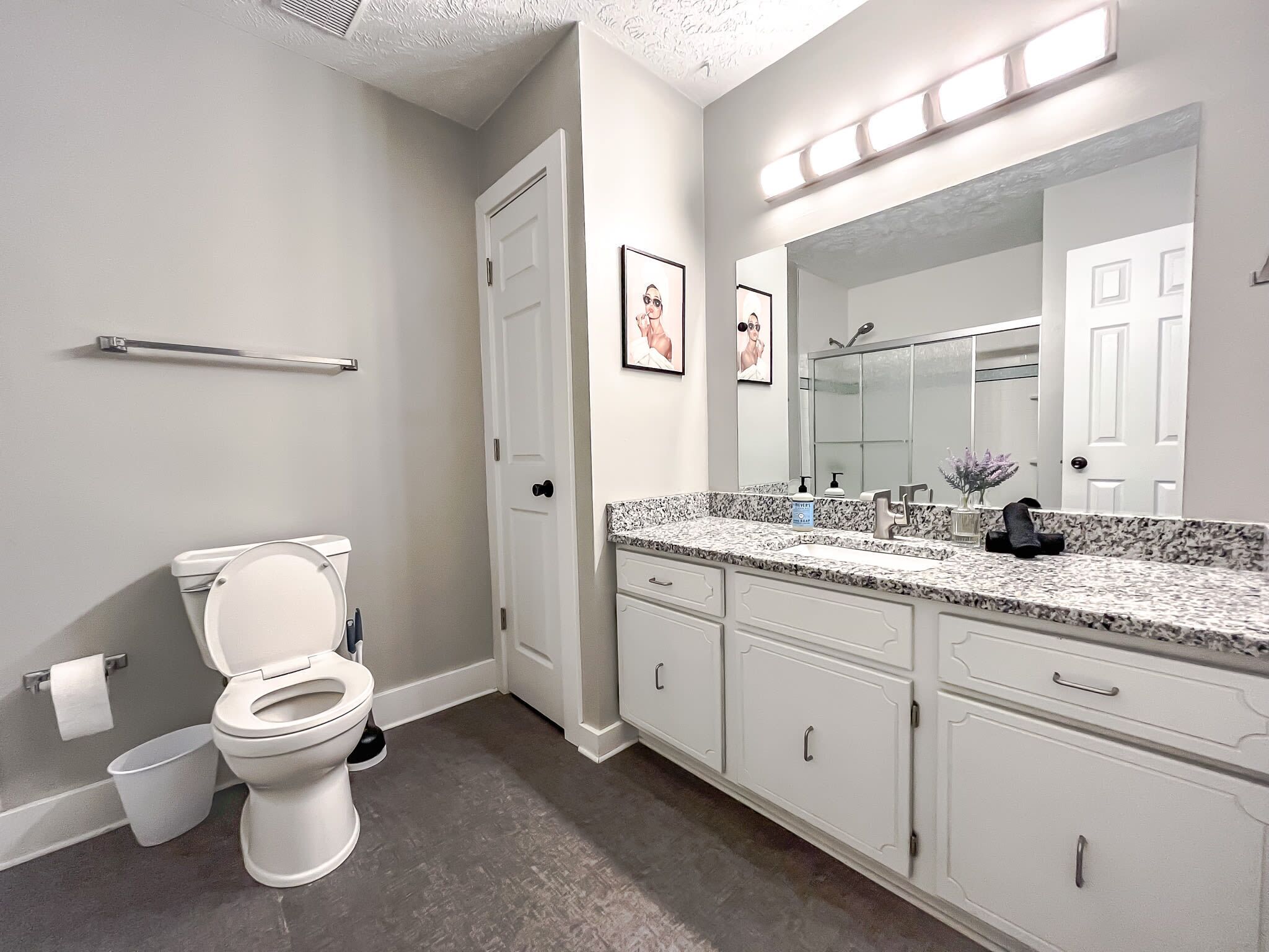 A bathroom with a toilet, sink, and mirror.