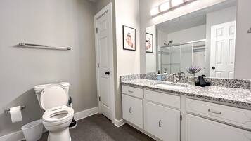 A bathroom with a toilet, sink, and mirror.