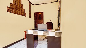 A room with a desk, a laptop, a chair, and a door. - Hotel O Fj Guest House (Cileunyi)