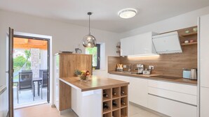 A modern kitchen with a wooden island, white cabinets, and a built-in wine rack. - Awesome home in Marcana (Marcana)