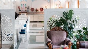 Un hall con mostrador de recepción, zona de estar y elementos decorativos.