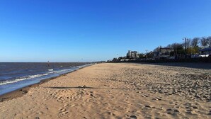 A beach with a clear sky, sandy shore, and buildings in the background. - Stylish 1-bed Studio in Humberston, Cleethorpes (Grimsby)