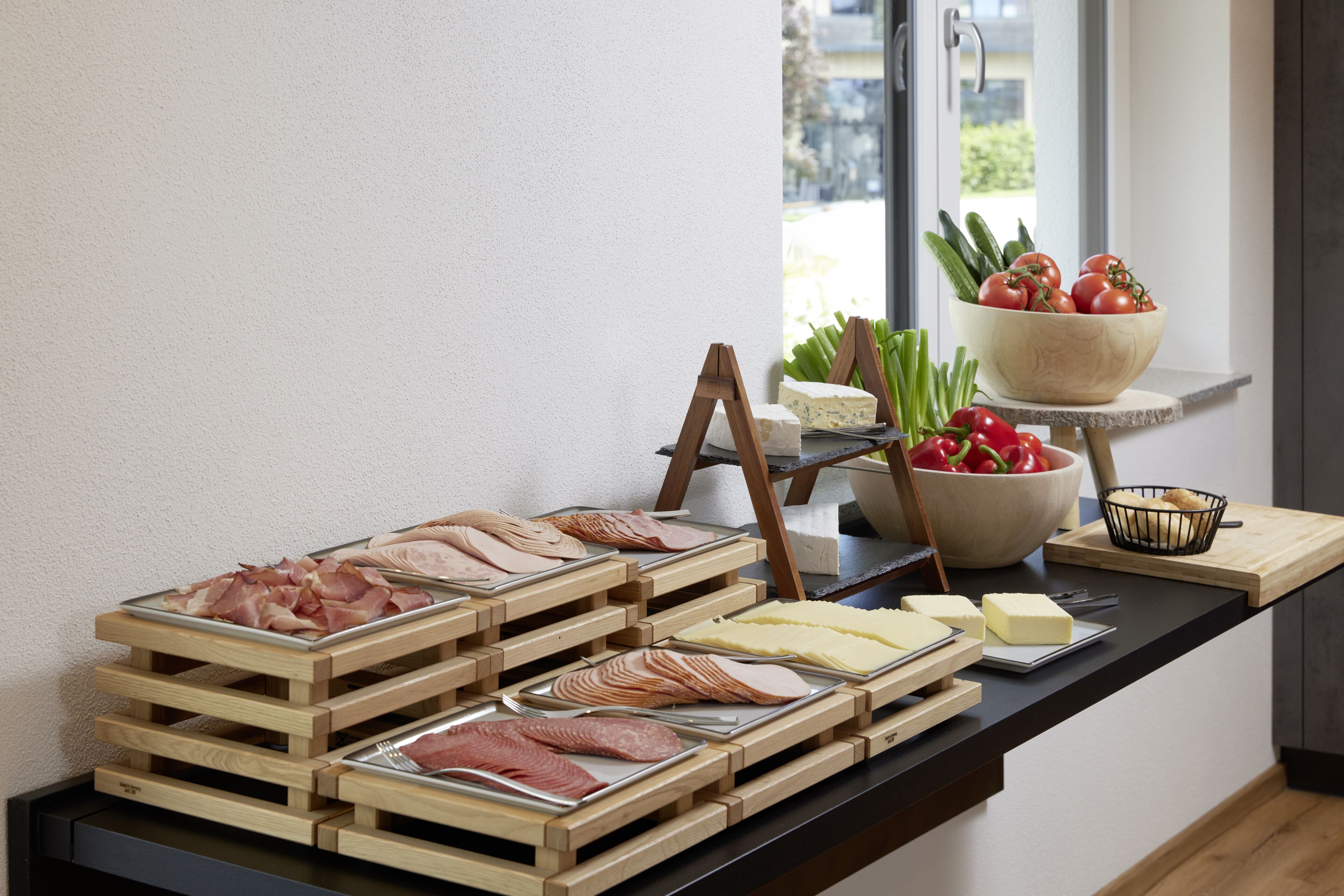 A buffet with various meats, cheeses, and vegetables.
