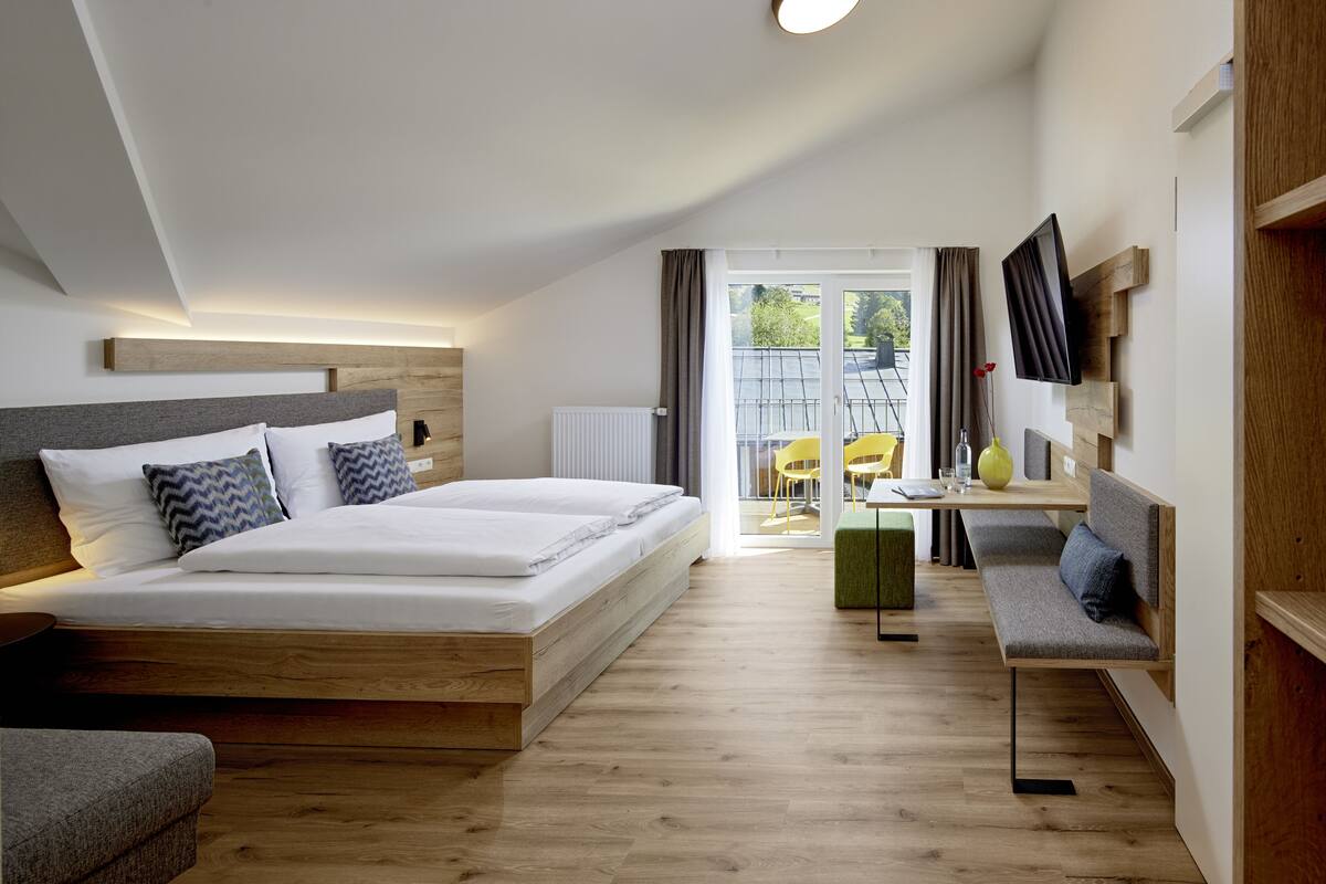 Ein modernes Hotelzimmer mit einem großen Bett, einem Schreibtisch und einer Sitzecke.