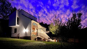 A modern house with a large balcony, a mural on the front wall, and a well-lit entrance. - Casa Rural Hitohouse Bed&climb (Albarracín)