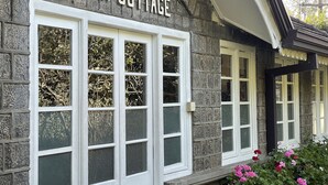 A stone building with a sign reading "Camp Cottage". - The Blossoms (Diyathalawa)