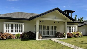 A two-story house with a covered porch, large windows, and a well-maintained lawn. - The Blossoms (Diyathalawa)