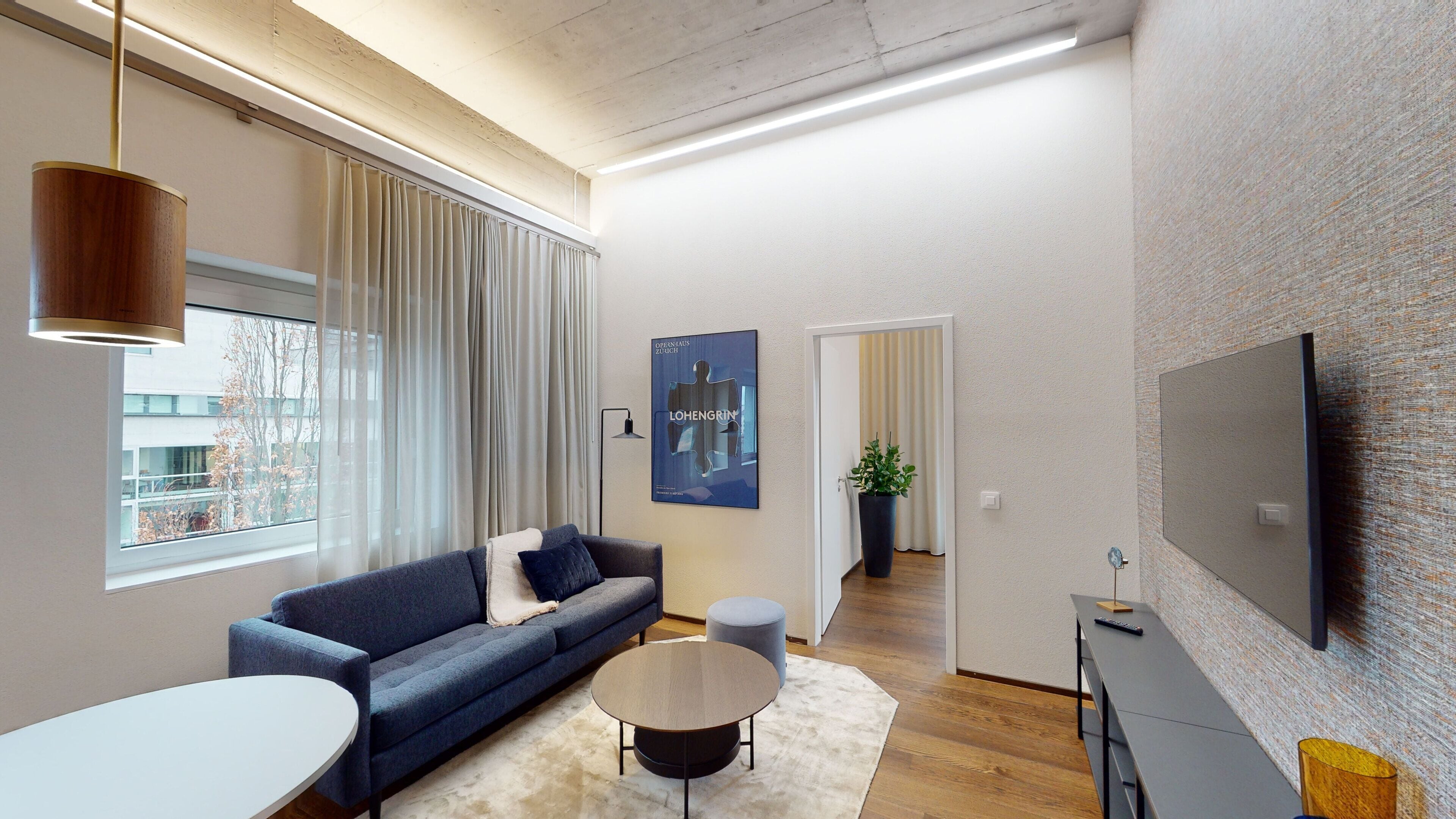 Un salon moderne avec un canapé, une table basse et un téléviseur.