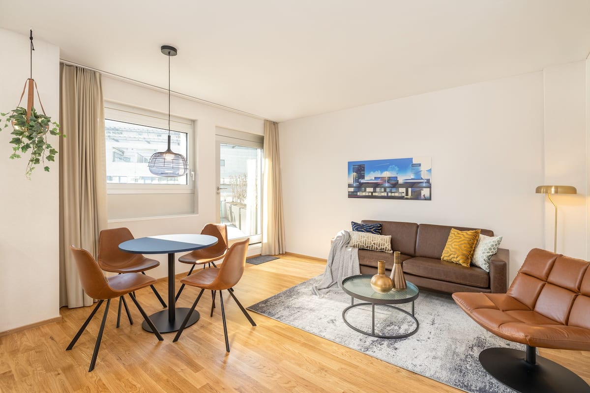 A modern living room with a dining area, a sofa, and a coffee table.