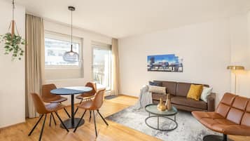 A modern living room with a dining area, a sofa, and a coffee table.