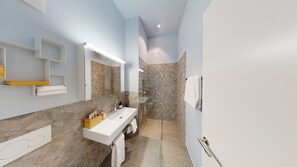 A modern bathroom with a white sink, a glass shower enclosure, and a tiled floor. - LivingTown Lofts Zurich (Zürich)
