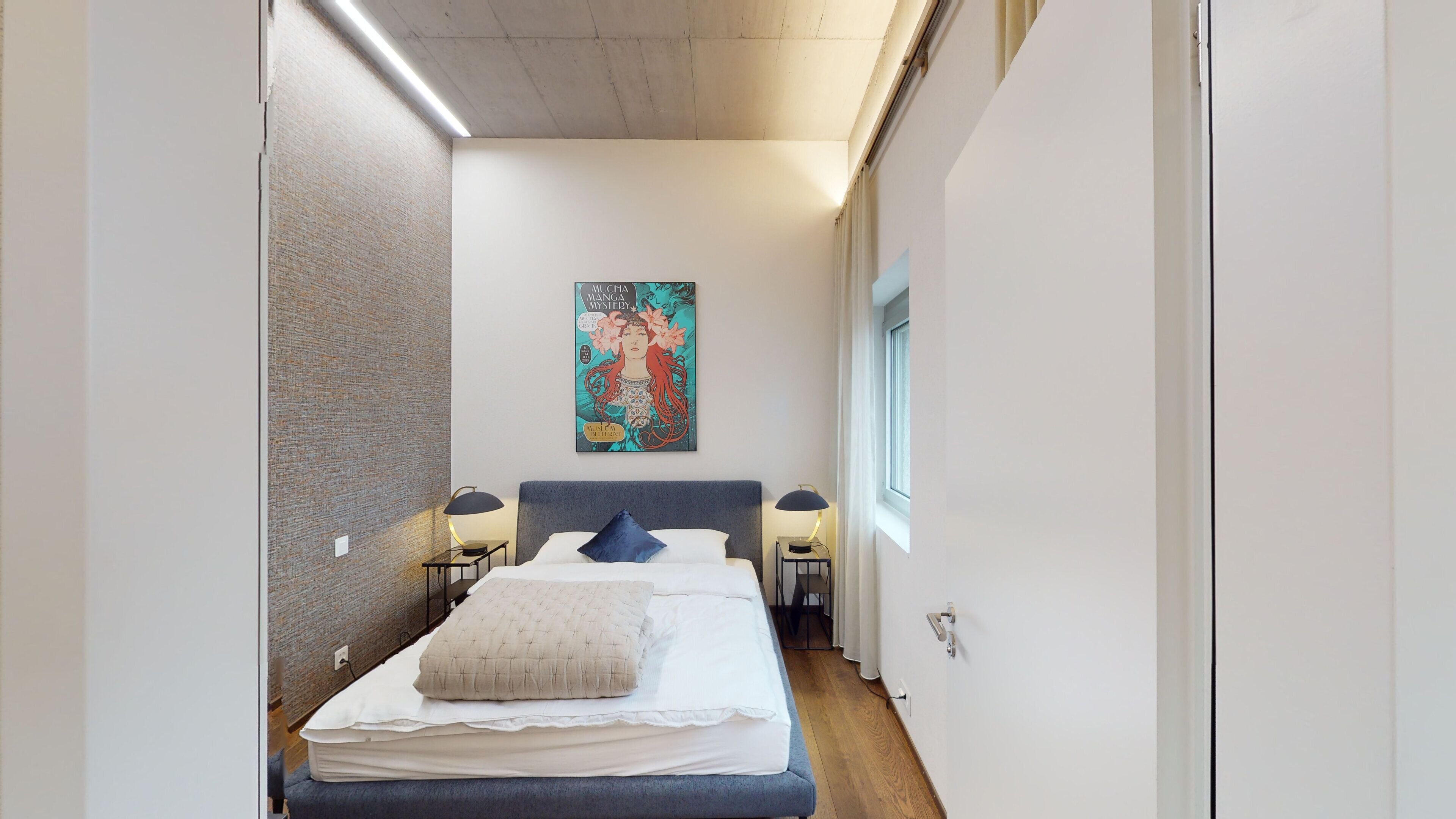 Een smalle hotelkamer met een bed, twee nachtkastjes, een wanddecoratie en een raam.