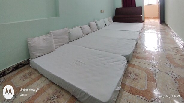 A hotel room with a large bed, a ceiling fan, and an air conditioning unit. - Sri Sivalakshmi AC Guest House (Vriddhachalam)