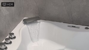 A white hot tub with a water fountain feature, multiple jets, and a control panel. - Stunning 1-bed Studio in Greenford (Greenford)