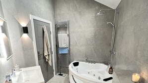 A modern bathroom with a bathtub, toilet, and sink. - Stunning 1-bed Studio in Greenford (Greenford)