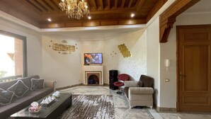 A living room with a fireplace, a television, and a chandelier. - Au Riad De La Palmeraie - Marrakech  (Marrakech)