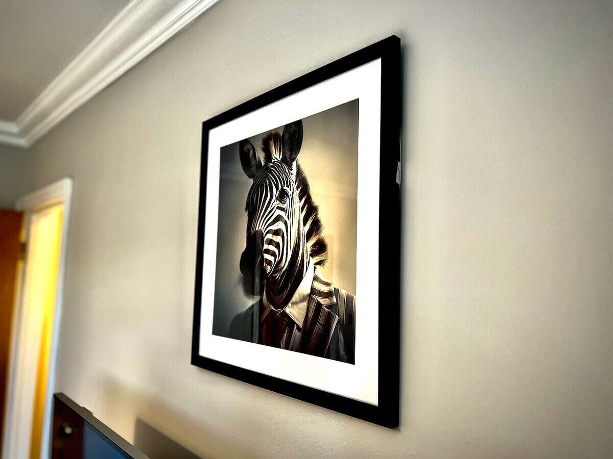 A framed artwork of a zebra on a wall.