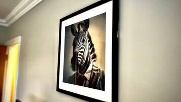 A framed artwork of a zebra on a wall.