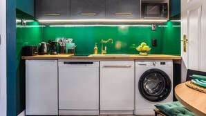 A compact kitchen with a dishwasher, washing machine, and a microwave.