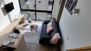 Een moderne woonkamer met een bank, salontafel en eettafel.