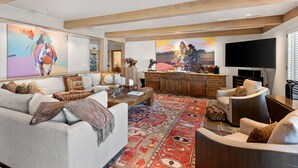 A spacious living room with a large rug, a sofa set, a coffee table, and a flat-screen TV. - Aspen Alps Three bedroom condo  - ski in / out of Aspen Mountain & Hot Tub (Aspen)