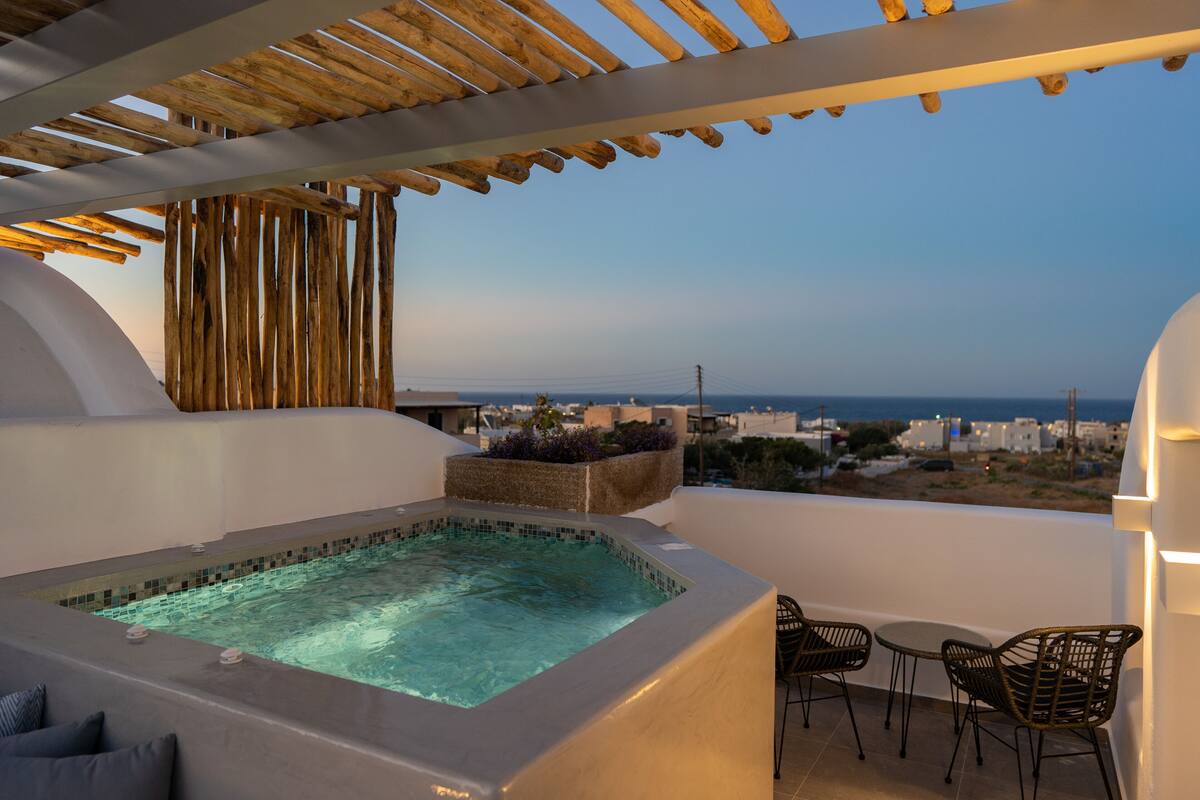 Terraço no terraço com hidromassagem, área de estar externa e vista para a cidade e o mar.