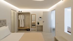 Et moderne soveværelse med seng, walk-in closet, natbord med spejl og et lille vindue.