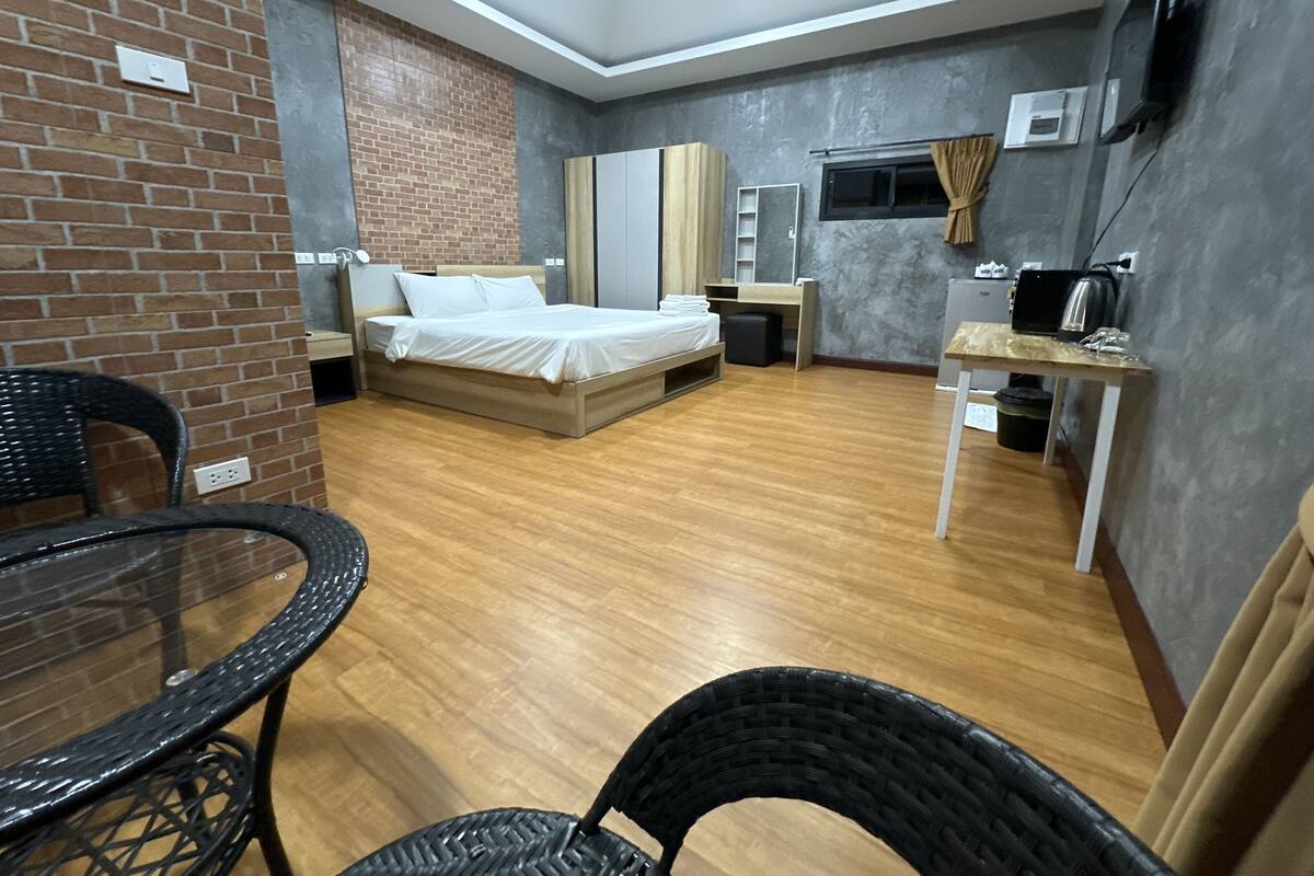 Habitación de hotel compacta con cama, escritorio, silla y televisión.