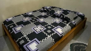 Una cama con una colcha y cojines estampados.