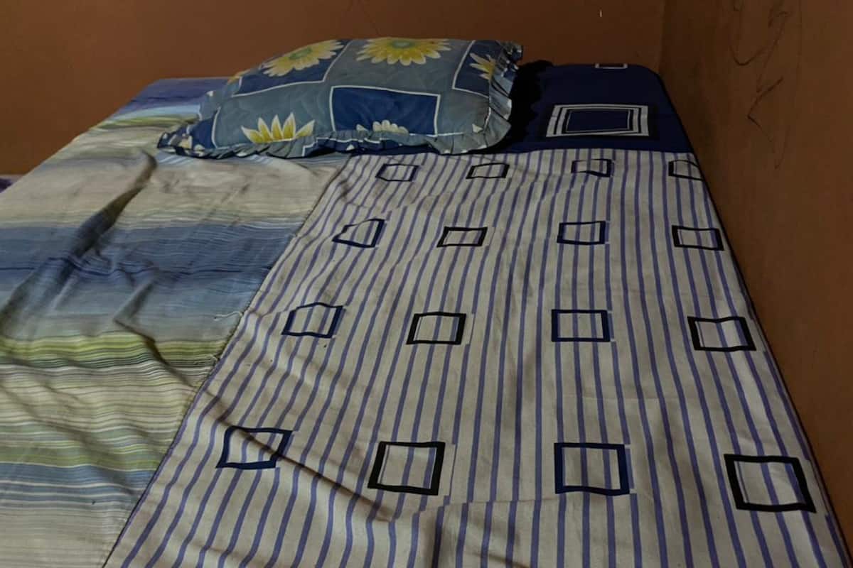 Ein Bett mit gestreifter Bettwäsche und einem Blumenkissen.