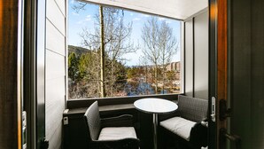 A room with a large window, a round table, and two chairs. - Nostalgic Mountain Getaway, Only a Short Walk to Lifts or River Run! (Keystone)