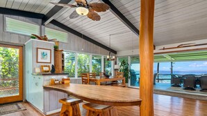 A spacious kitchen with a large wooden island, wooden cabinets, and a ceiling fan.
