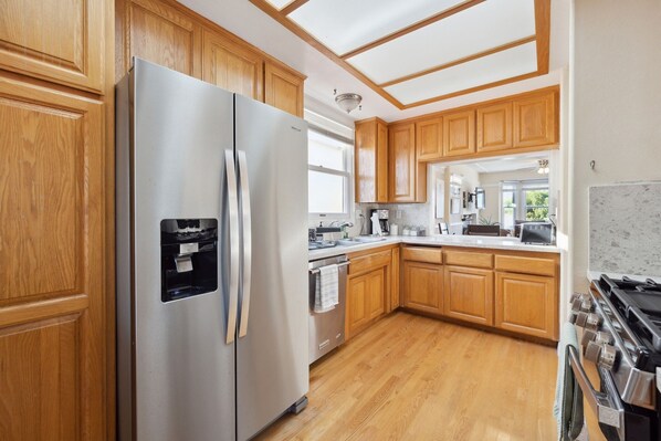 A kitchen with wooden cabinets, stainless steel appliances, and a tiled backsplash.