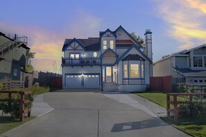 A two-story house with a garage, a balcony, and a chimney.