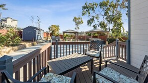 A wooden deck with outdoor furniture, a barbecue area, and a pergola. - Talal R Muhtaseb (Oceanside)