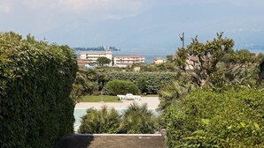 Vista de una zona costera con edificios, piscina y abundante vegetación.