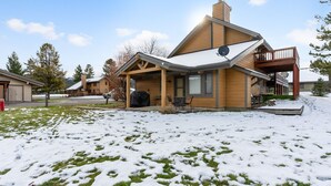 Une maison à deux étages avec une terrasse couverte et une plateforme.