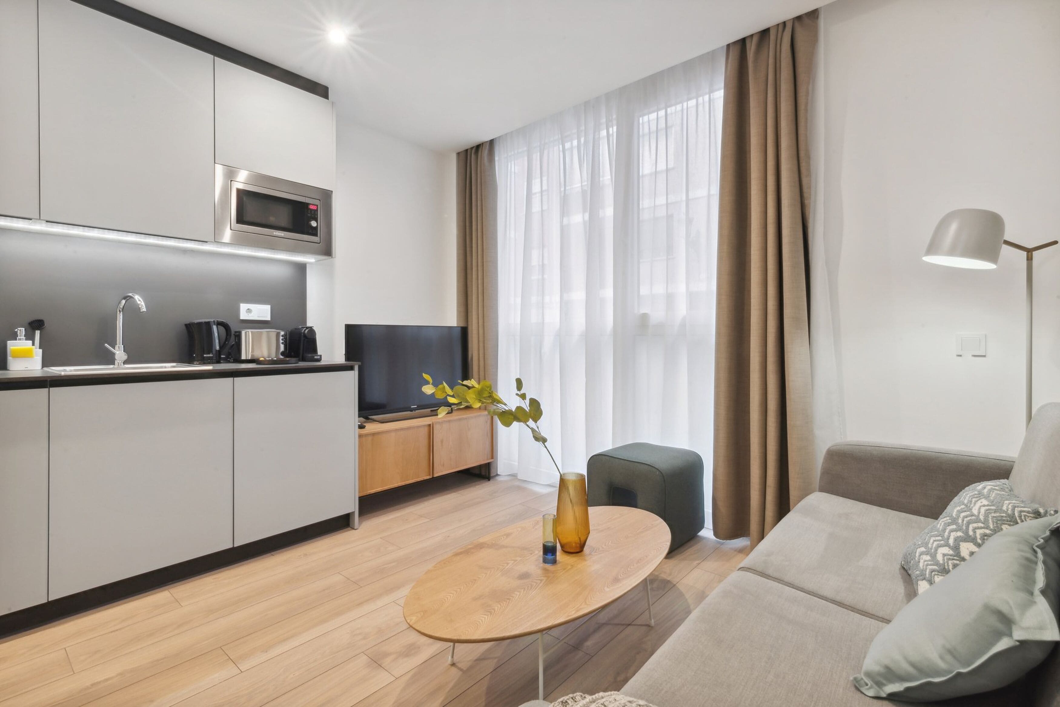 Una sala de estar moderna con un sofá, una mesa de centro y un televisor.