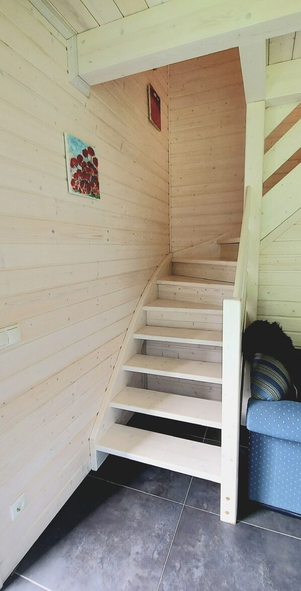 A wooden staircase with a handrail, leading to a lower level.