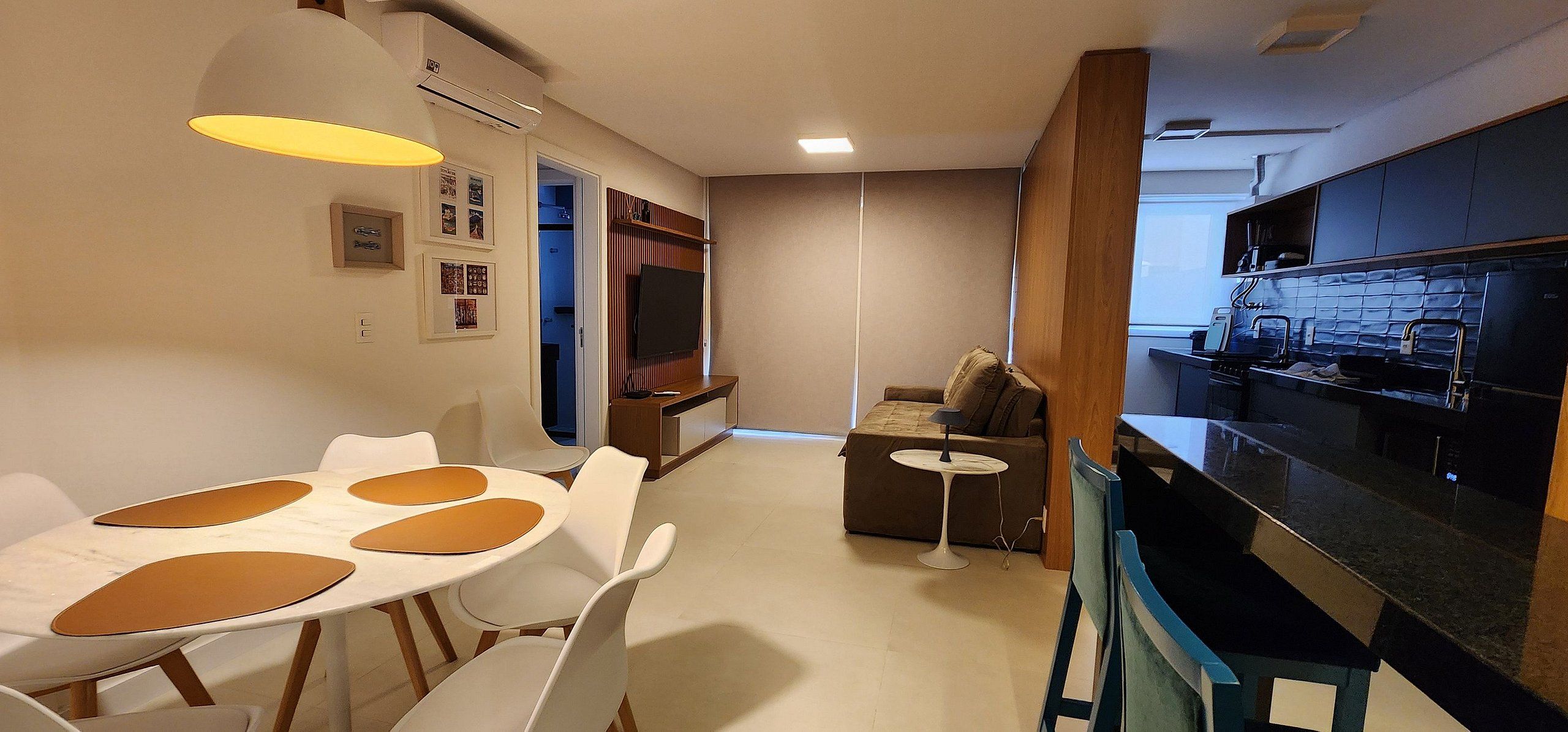 A compact living space with a dining area, kitchenette, and a small seating area.