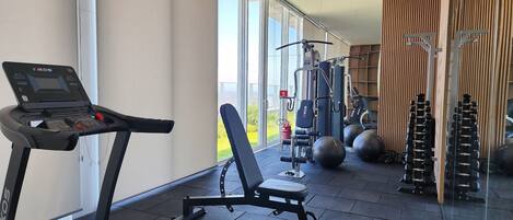A gym with cardio equipment, weight machines, and free weights.