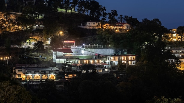 A hotel with multiple buildings, including a main structure with a red roof and a smaller building with a green roof. - Treebo Stotrak S N Residency, Mussoorie (Dehradun)
