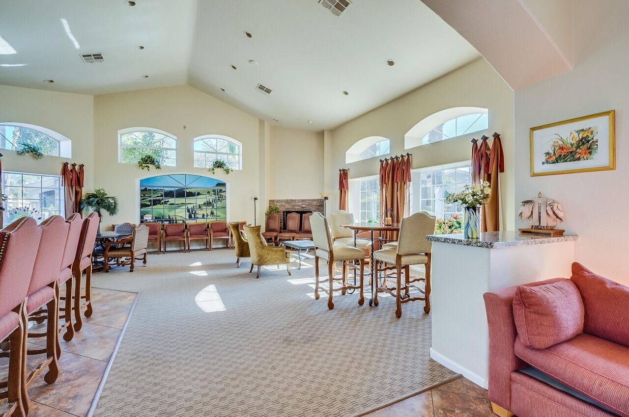 A spacious living area with a fireplace, a dining table with chairs, and a sofa.