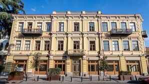 A multi-story building with a symmetrical facade, large windows, and balconies. - H&B apartments Atoneli (Tbilisi)