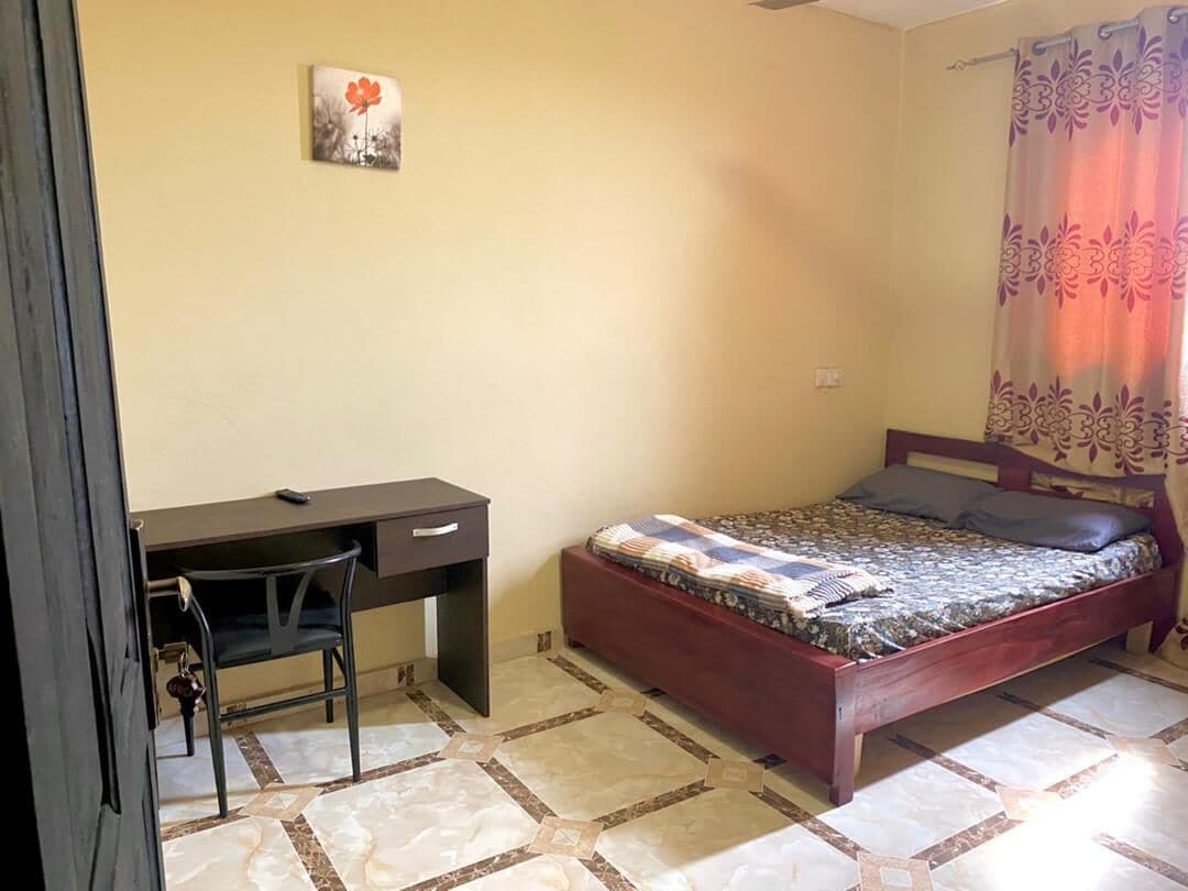 Un dormitorio con una cama, un escritorio y una silla.