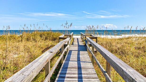 A wooden boardwalk leading to a beach with grassy dunes and the ocean in the background. - 🏖️Ocean Overlook-Beautiful 6BR Oceanfront Top 2 Floors of a Duplex🏖️ (Carolina Beach)